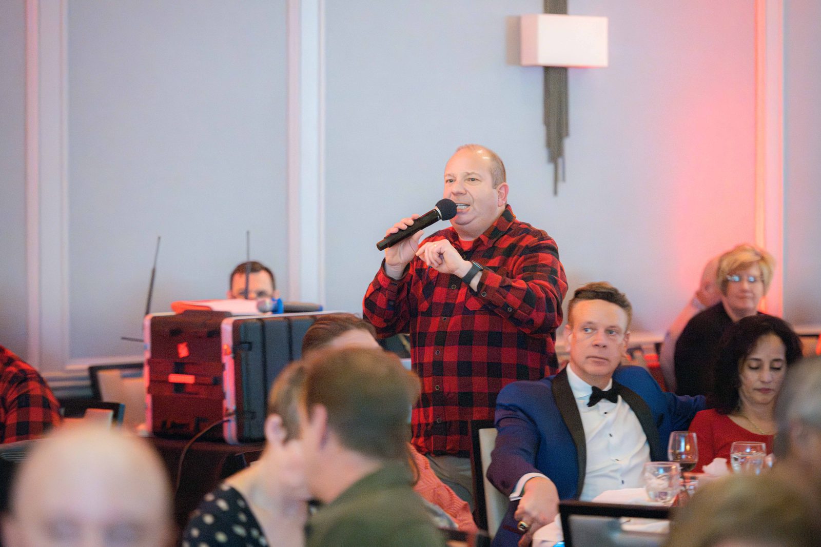 Benefit auctioneer Geoffrey Sandler on the microphone among the guests' tables during the Do Good Gala